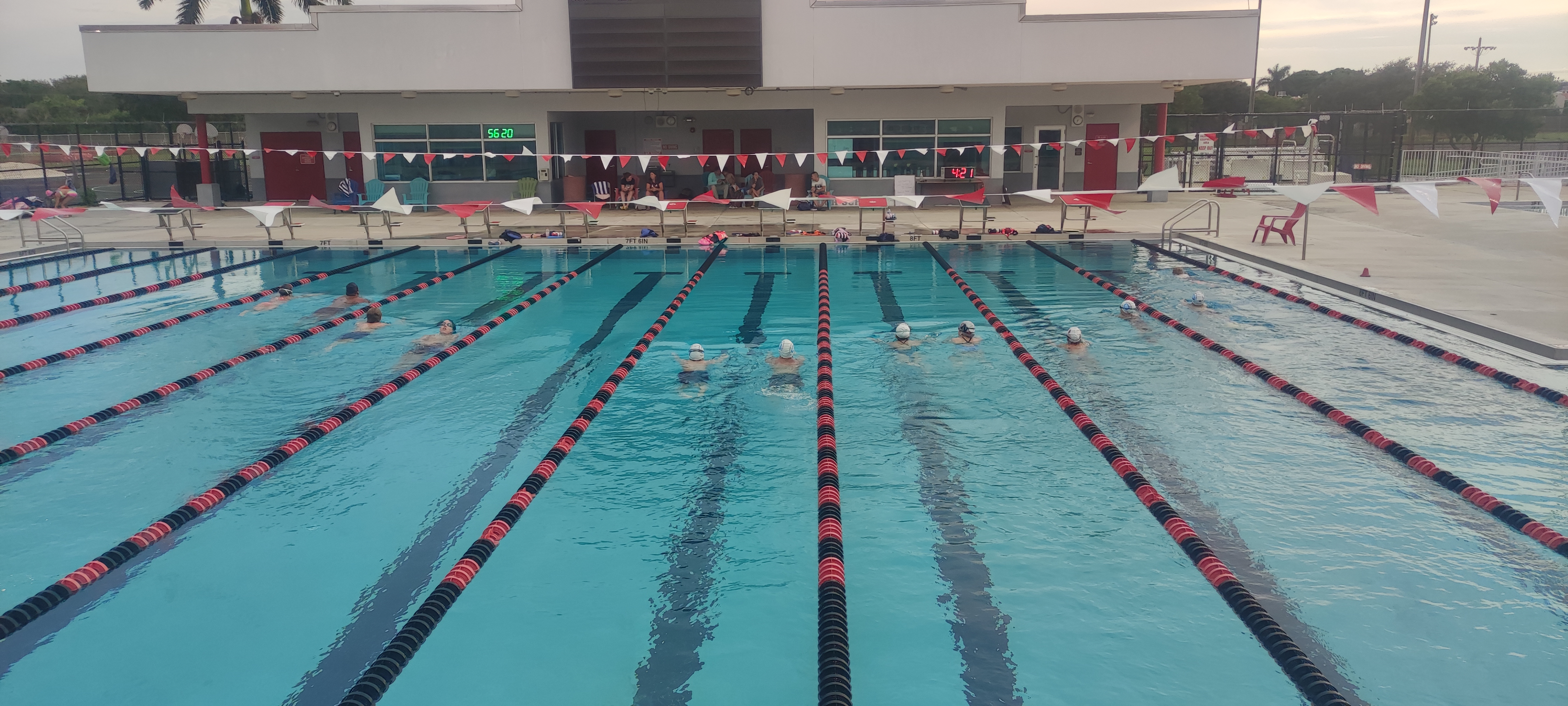 Swimmers and spectators gathered for a Four Strokes event at an outdoor pool